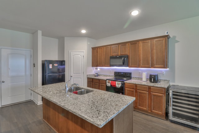 kitchen featuring dark hardwood / wood-style floors, a kitchen island with sink, sink, black appliances, and beverage cooler