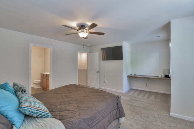 carpeted bedroom featuring ensuite bath and ceiling fan