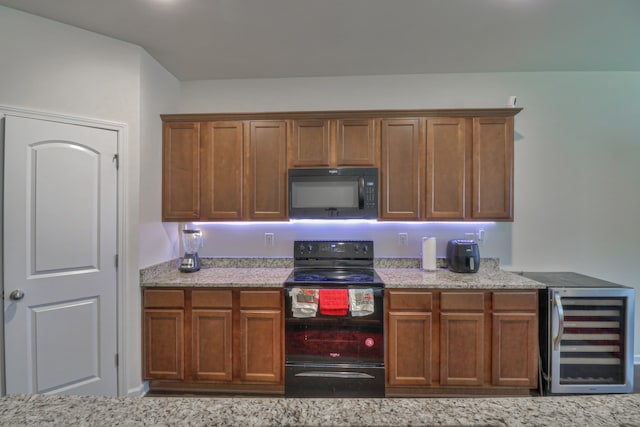 kitchen featuring light stone counters, beverage cooler, and black appliances