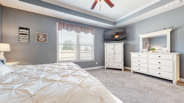 bedroom featuring ceiling fan, crown molding, light carpet, and a tray ceiling