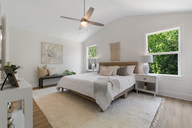 bedroom featuring light hardwood / wood-style floors, ceiling fan, and vaulted ceiling