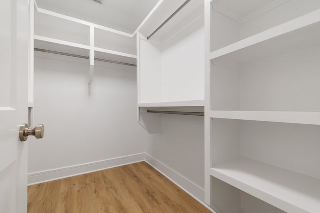 walk in closet with light wood-type flooring