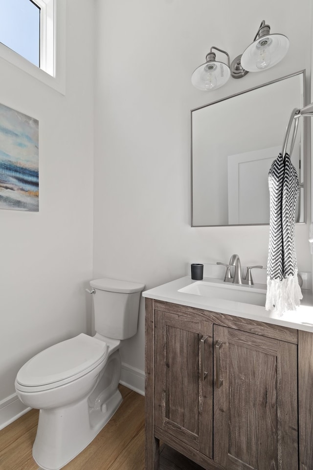 bathroom featuring toilet, hardwood / wood-style flooring, and vanity