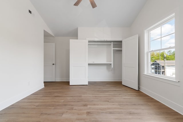 unfurnished bedroom featuring ceiling fan, a closet, lofted ceiling, and light hardwood / wood-style floors