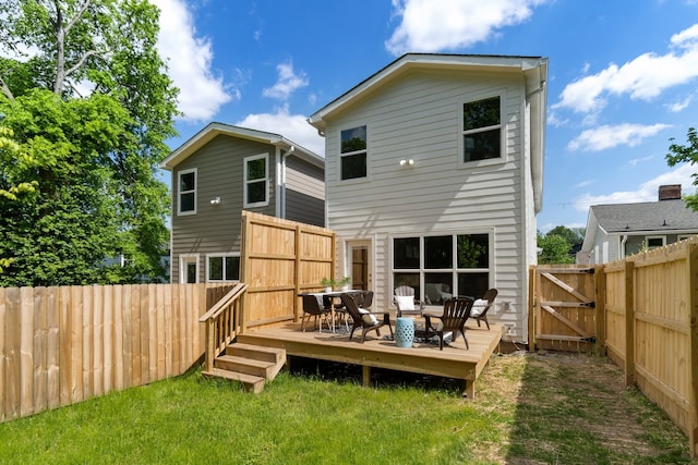 rear view of property with a deck and a lawn