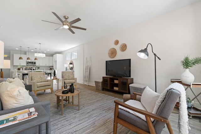 living room featuring ceiling fan and light wood-type flooring