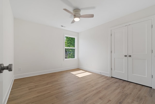 unfurnished bedroom with a closet, light hardwood / wood-style floors, and ceiling fan