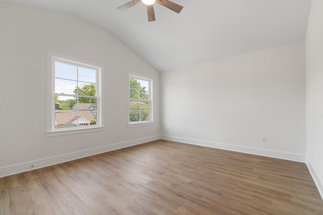 spare room with ceiling fan, vaulted ceiling, and light wood-type flooring