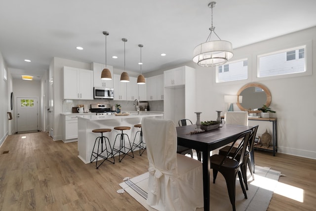 dining room featuring light hardwood / wood-style flooring, sink, and plenty of natural light