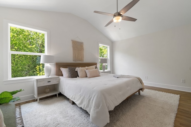 bedroom featuring multiple windows, ceiling fan, vaulted ceiling, and dark wood-type flooring