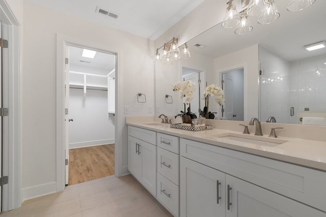 bathroom with walk in shower, double vanity, a notable chandelier, and tile flooring