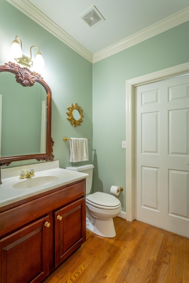 bathroom featuring crown molding, toilet, vanity, and wood-type flooring