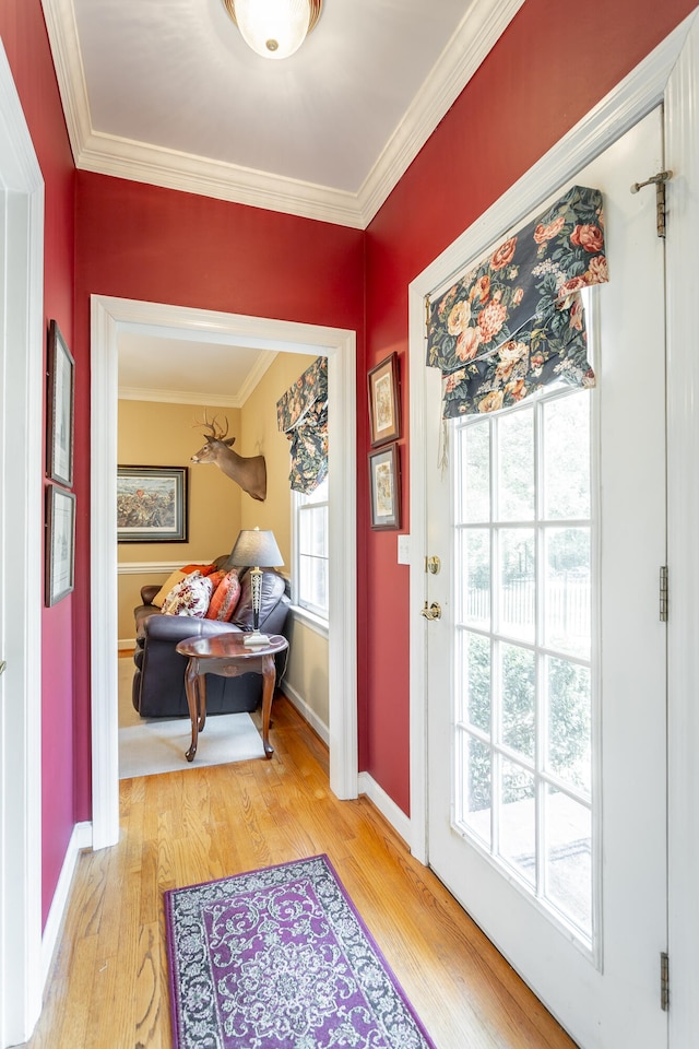 doorway to outside featuring ornamental molding and light hardwood / wood-style floors