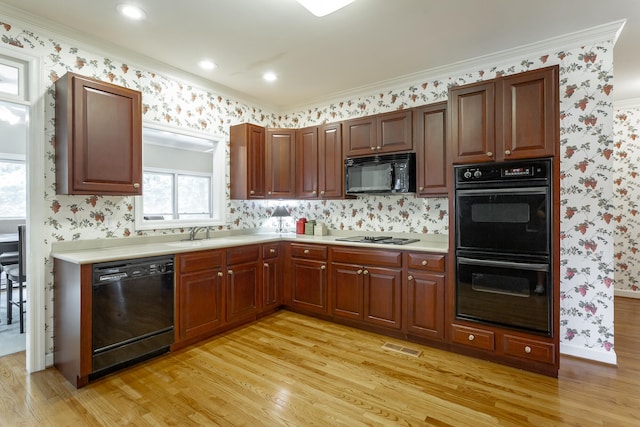 kitchen with tasteful backsplash, sink, light hardwood / wood-style flooring, black appliances, and ornamental molding