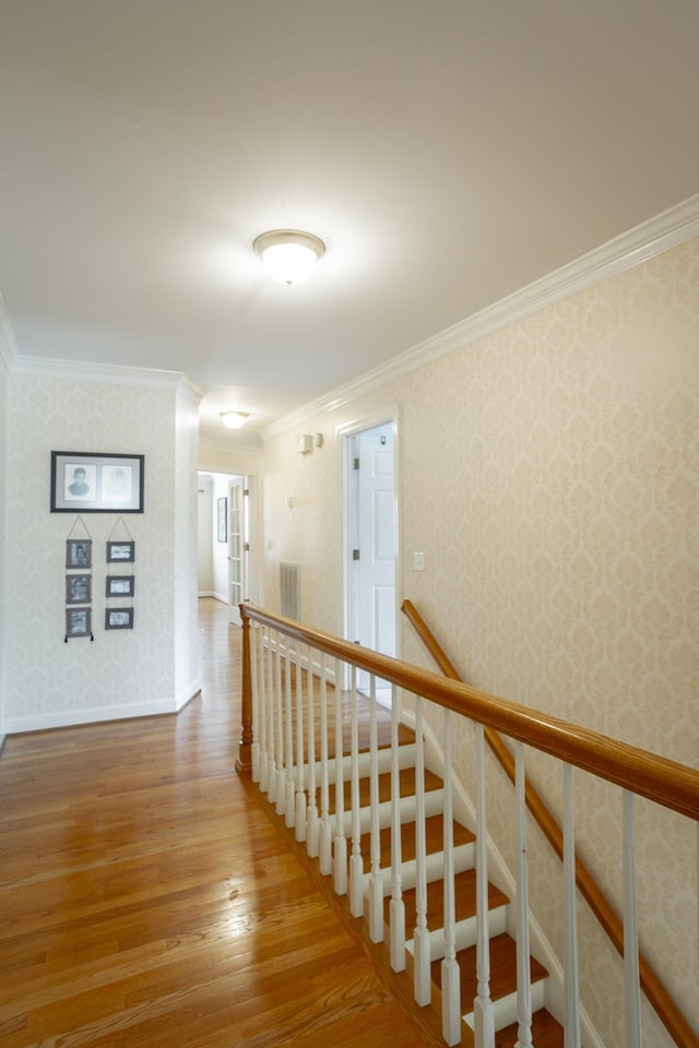 hallway featuring crown molding and light hardwood / wood-style floors