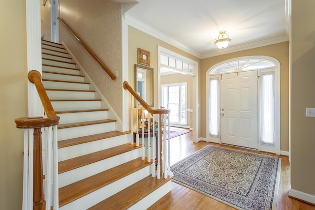 entryway with light hardwood / wood-style floors and ornamental molding