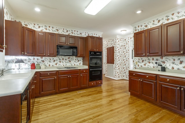 kitchen with sink, ornamental molding, black appliances, tasteful backsplash, and light wood-type flooring