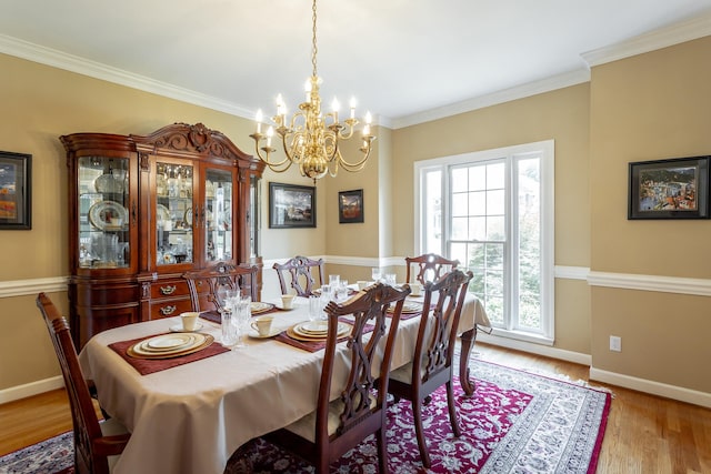 dining room featuring ornamental molding, a chandelier, and light wood-type flooring