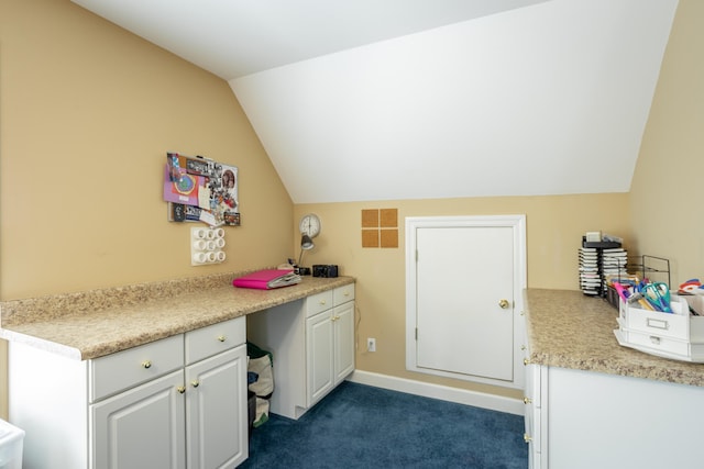 interior space with white cabinets, dark colored carpet, and lofted ceiling