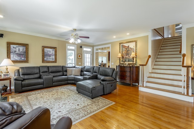 living room with crown molding, ceiling fan, and light wood-type flooring