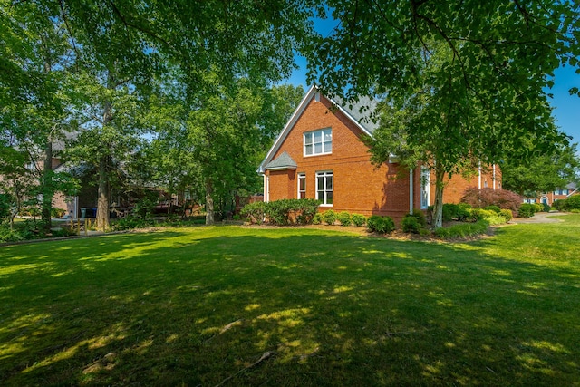 view of side of home with a yard