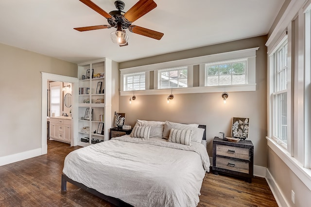 bedroom featuring ceiling fan, ensuite bath, and dark wood-type flooring