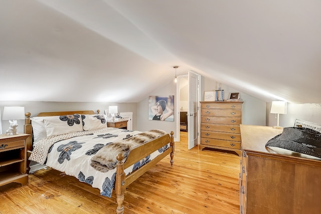 bedroom featuring lofted ceiling and light wood-type flooring