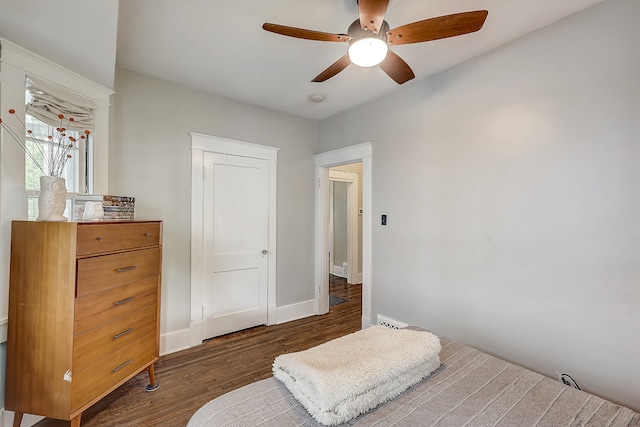 bedroom with dark hardwood / wood-style flooring and ceiling fan