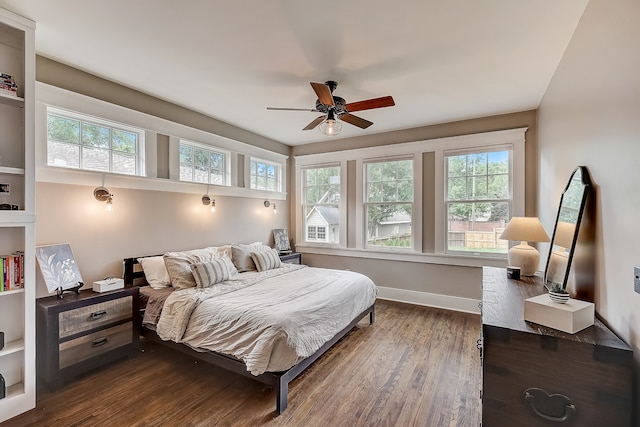 bedroom featuring multiple windows, dark hardwood / wood-style floors, and ceiling fan