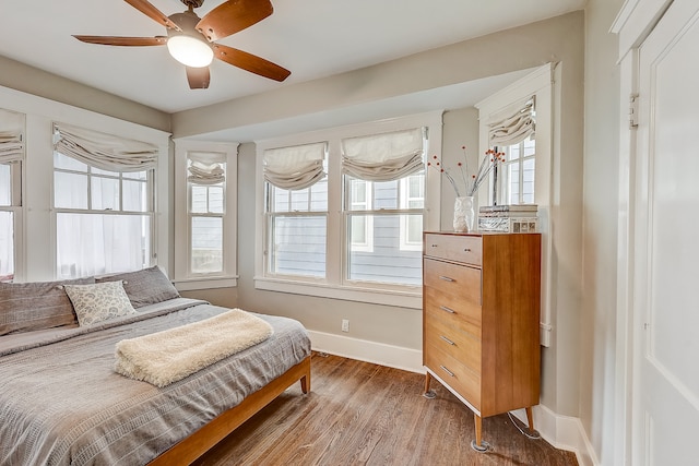 bedroom featuring multiple windows, ceiling fan, and hardwood / wood-style flooring