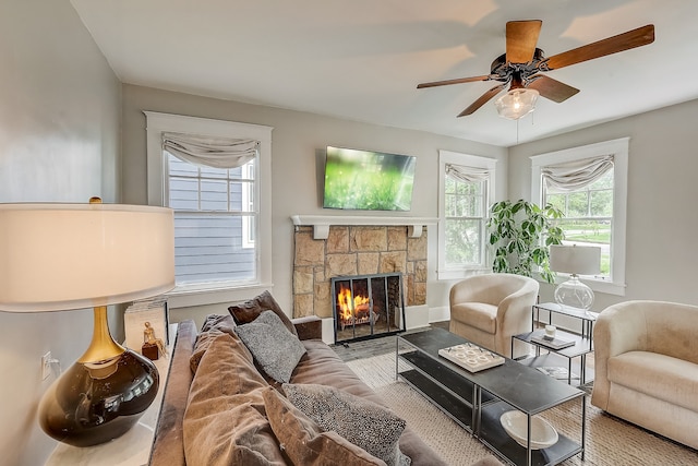 living room featuring a fireplace and ceiling fan