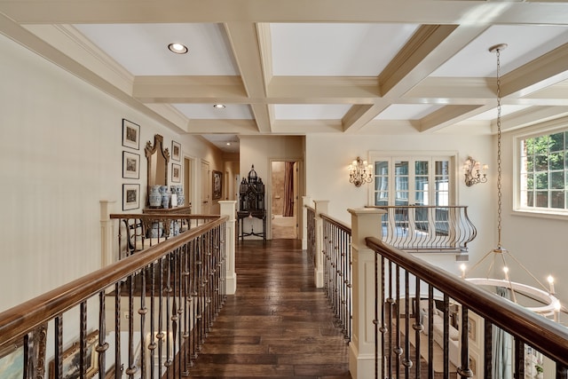 corridor with coffered ceiling, an inviting chandelier, dark wood-type flooring, and beam ceiling