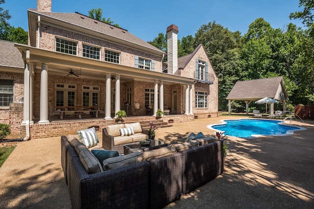 view of pool featuring a patio area, an outdoor living space, and ceiling fan