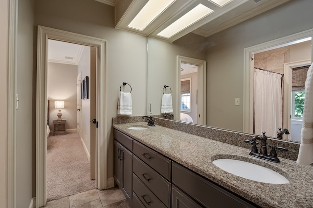 bathroom featuring crown molding, double sink vanity, and tile floors