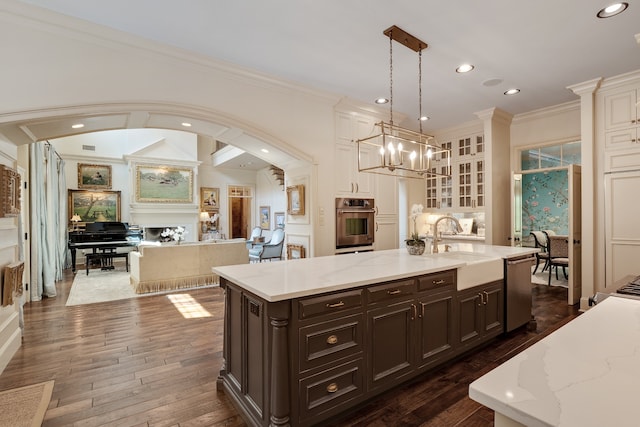 kitchen featuring an island with sink, a chandelier, dark hardwood / wood-style flooring, and pendant lighting