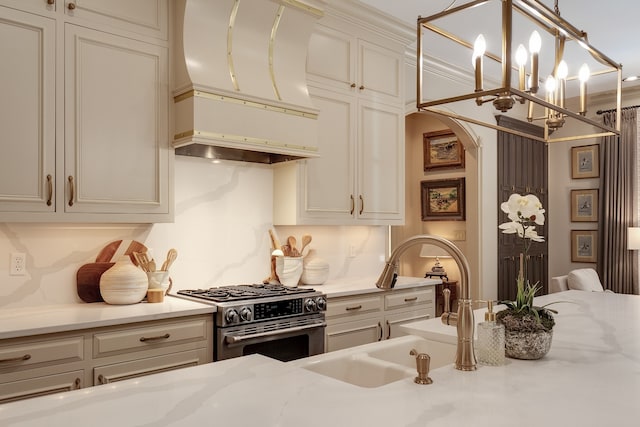 kitchen with an inviting chandelier, premium range hood, decorative light fixtures, light stone countertops, and gas stove