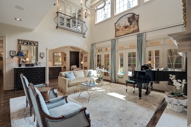 interior space featuring a chandelier, french doors, a towering ceiling, and light hardwood / wood-style flooring