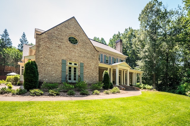 back of property featuring french doors and a lawn