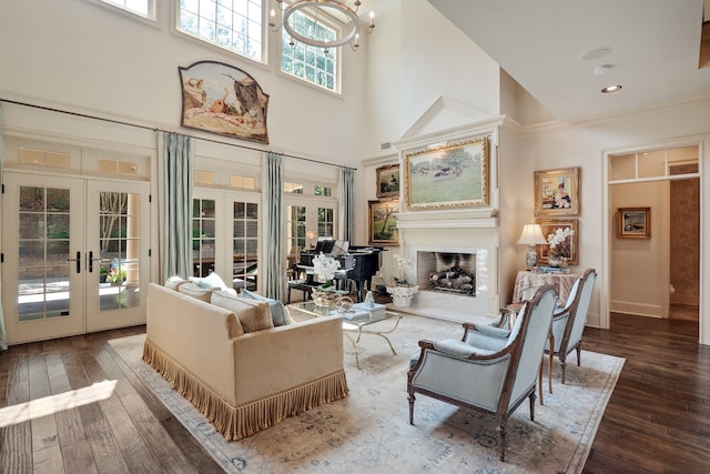 sitting room featuring a high ceiling, wood-type flooring, french doors, and an inviting chandelier