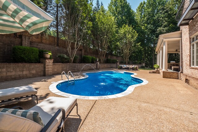 view of pool with pool water feature, outdoor lounge area, and a patio