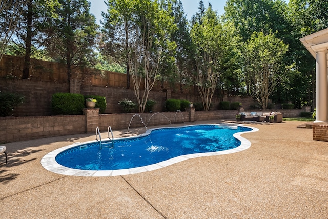 view of swimming pool featuring pool water feature and a patio