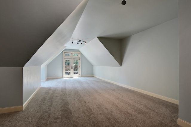 bonus room with light carpet and vaulted ceiling