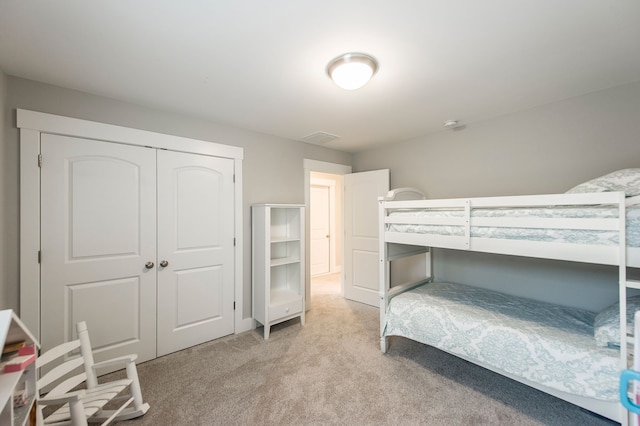 bedroom featuring light carpet and a closet