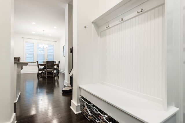 mudroom featuring an inviting chandelier and dark wood-type flooring