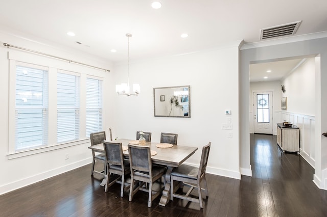 dining area featuring an inviting chandelier, ornamental molding, and dark wood-type flooring