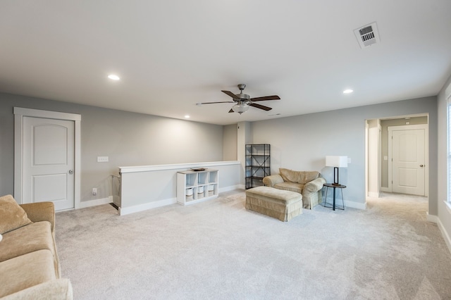 living area featuring ceiling fan and light colored carpet