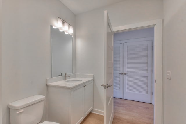 bathroom featuring vanity, wood-type flooring, and toilet