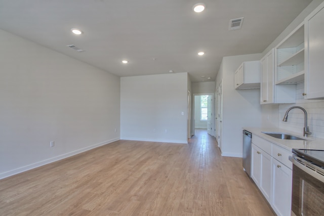 kitchen with stainless steel appliances, light hardwood / wood-style flooring, white cabinetry, backsplash, and sink