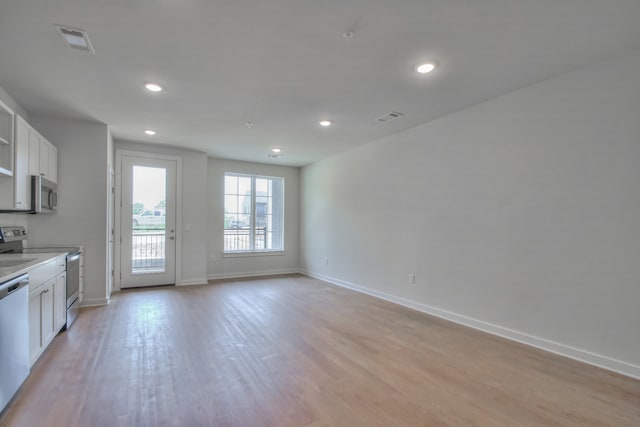 kitchen featuring dishwashing machine, electric stove, light hardwood / wood-style floors, and white cabinets