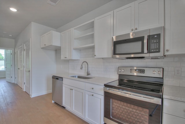 kitchen featuring white cabinets, sink, appliances with stainless steel finishes, and light hardwood / wood-style flooring